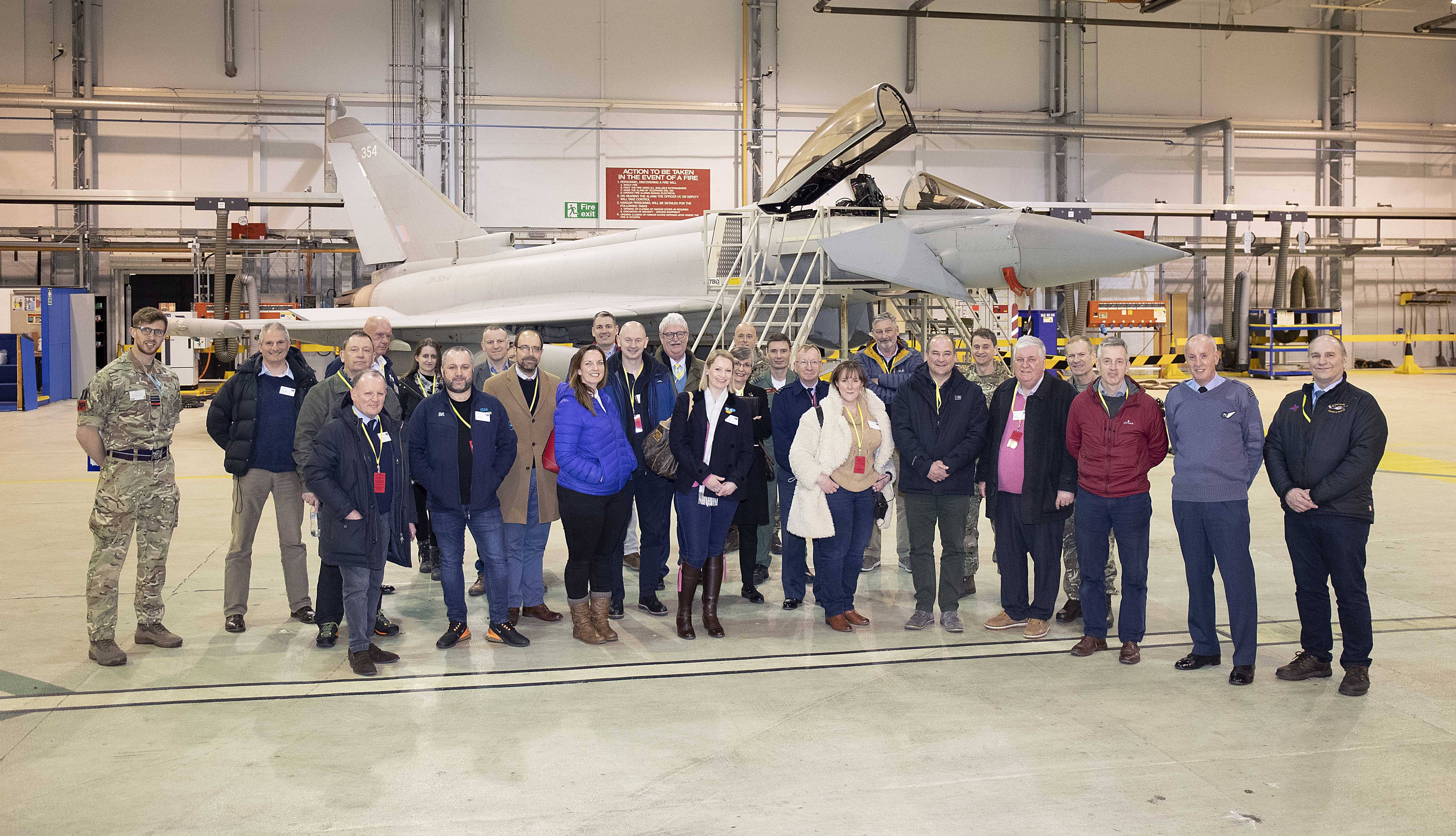 Personnel and members of the public stand by a Typhoon in the hangar.